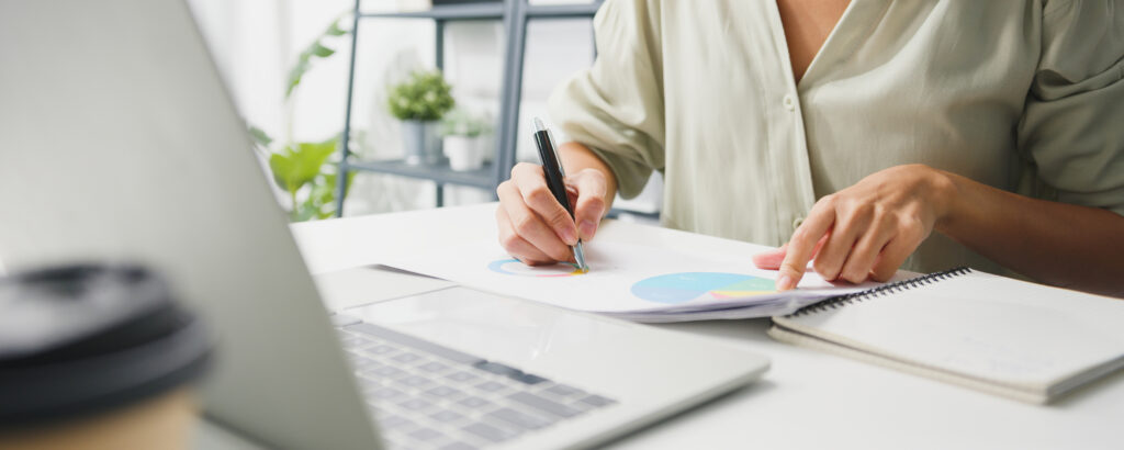 Person sitting at desk planning their week in a notebook representing weekly productivity planning